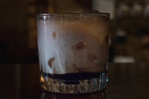 Irish Coffee in a heavy glass with cream swirled through