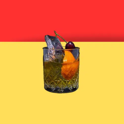 New York Sour in a rocks glass with an orange wedge and a cherry