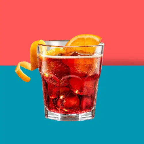 Red Geez Louise over ice in a rocks glass with orange slices