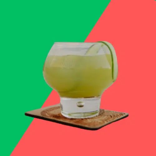 Sun and Fun in a round glass on a coaster with a lime wheel