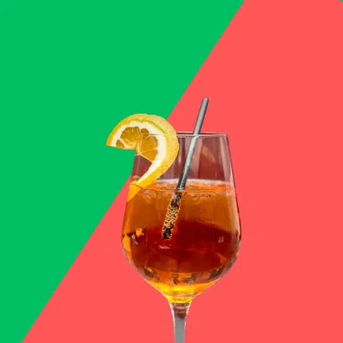 Cranberry Aperol Spritz in a wine glass with an orange slice and a straw